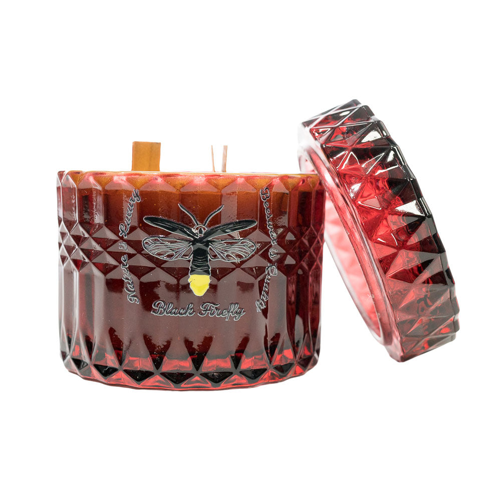 Decorative candle with geometric design and bee illustration on a white background
