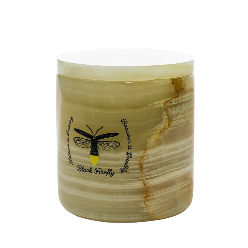 Decorative candle with a black fly illustration and text on a white background