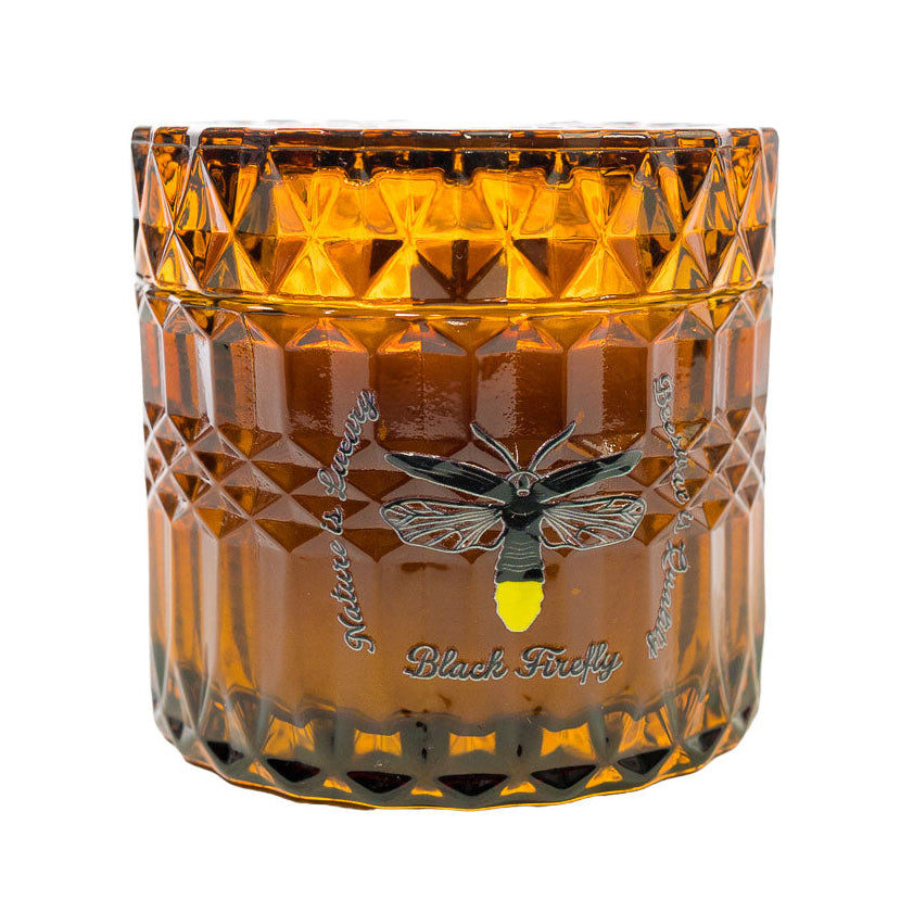 Amber glass candle with diamond pattern and 'Black Friday' branding on a white background